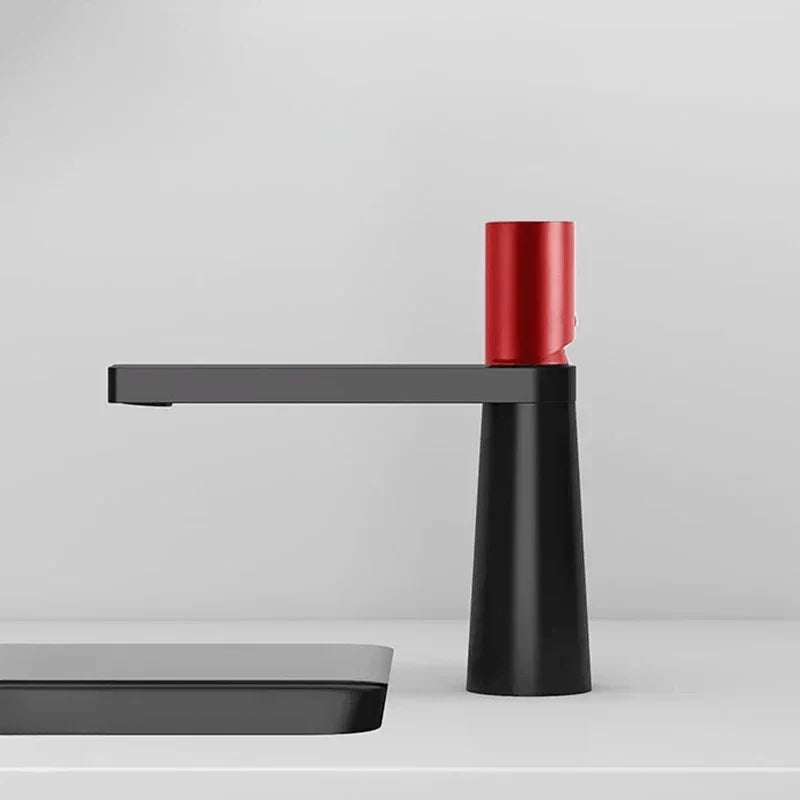 View from below of a black faucet with red accents
